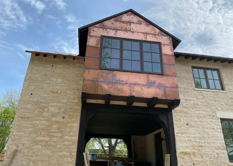 Copper metal panel facade on a stone building for Roof Repair in Saline